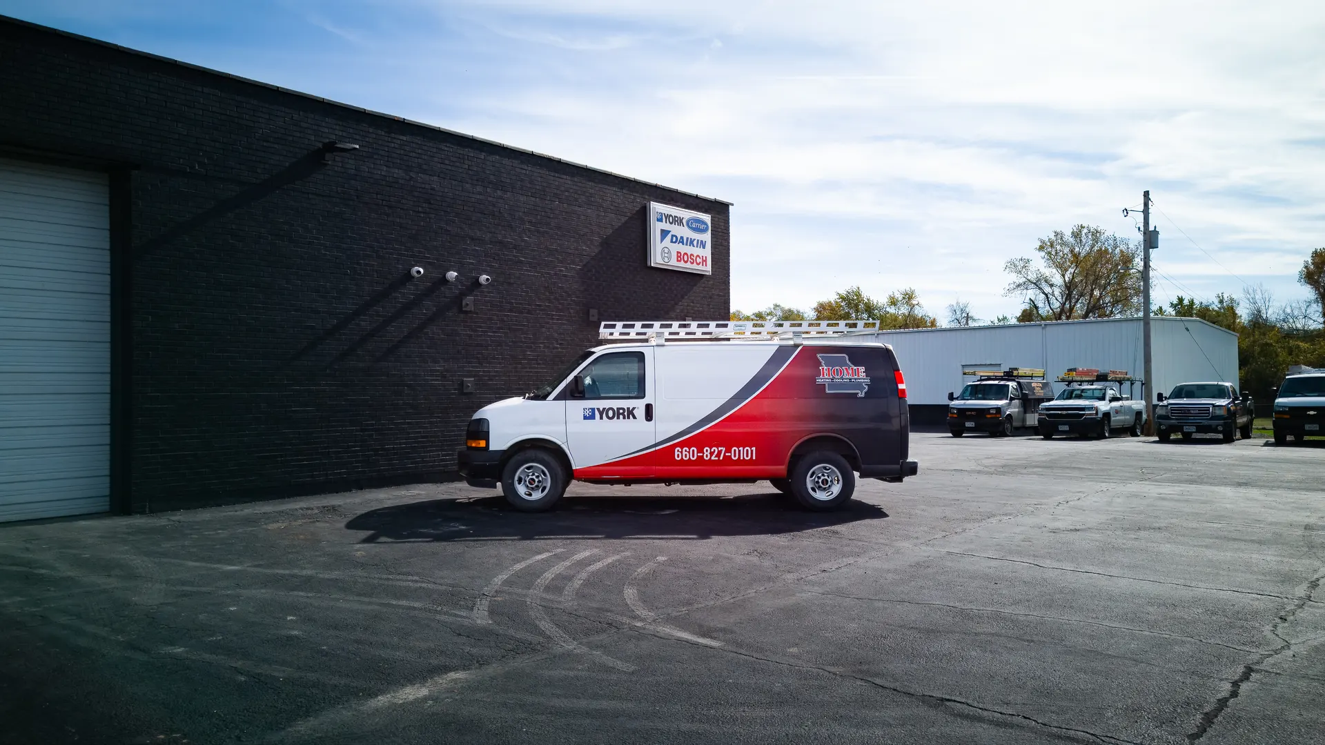 Home HVAC, Plumbing & Electrical branded service van outside the Sedalia shop